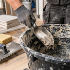 Close-up of 165mm stainless steel curved bucket scoop and scraper removing mortar from a mixing bucket