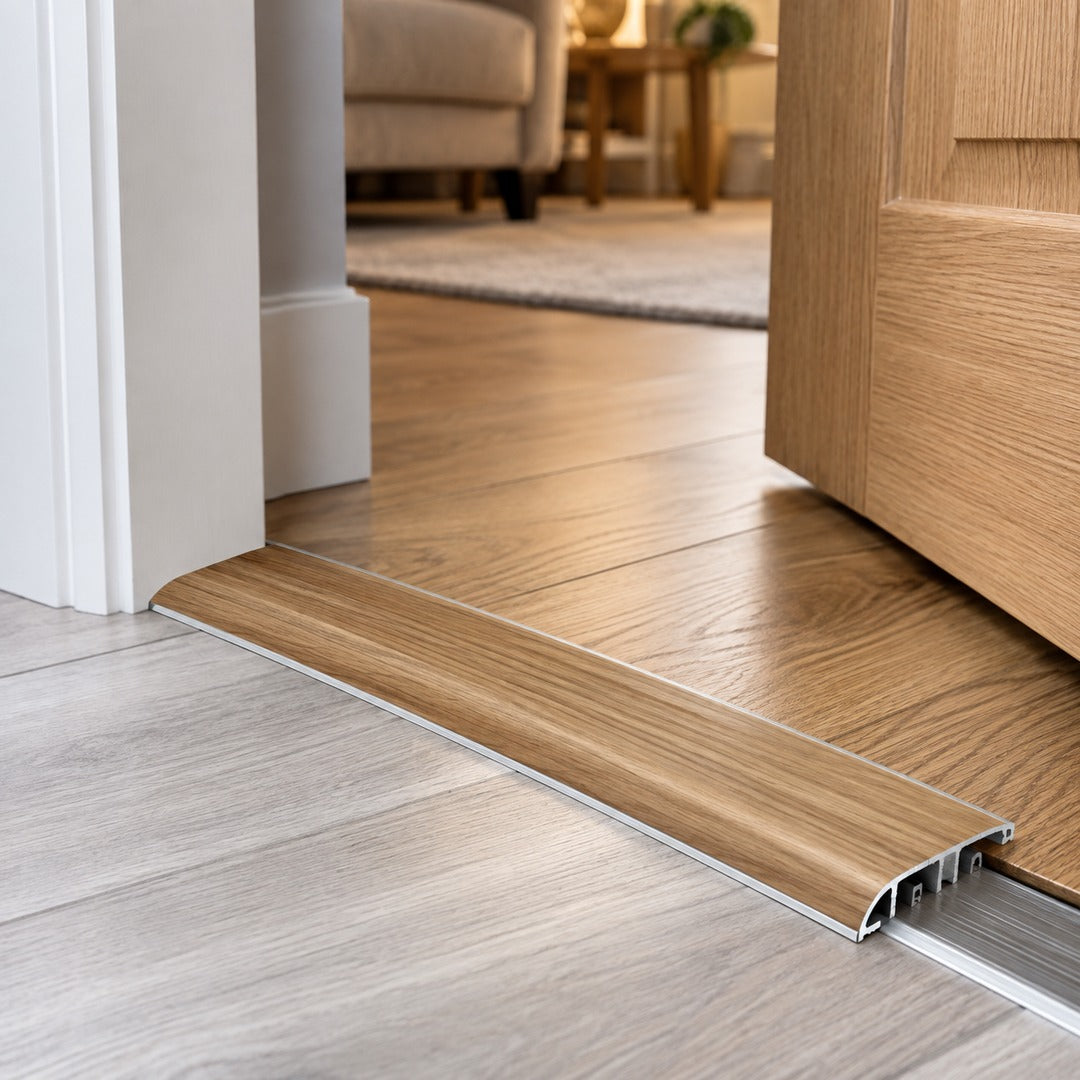 37mm aluminium wood-effect door threshold installed at a residential doorway between two floor surfaces