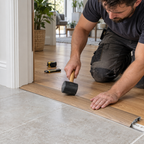 42mm PVC wood-effect door threshold being installed between wood flooring and tile in a modern home