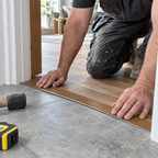 A02 30mm aluminium wood-effect self adhesive threshold strip being fitted between laminate flooring and tile