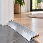 Close-up of A04 49mm anodised aluminium door threshold bridging wood flooring and darker tile at a doorway
