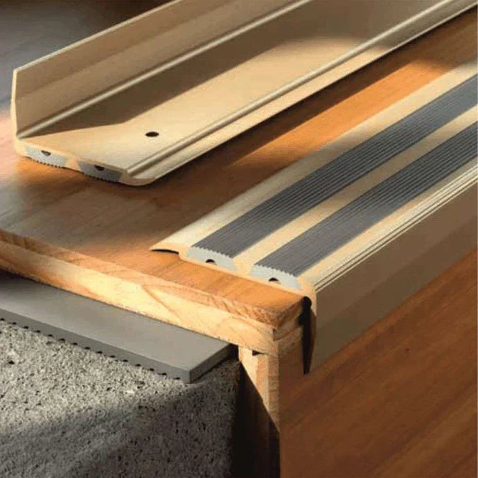 Aluminium step tread with rubberized surface, showing installation on a staircase.